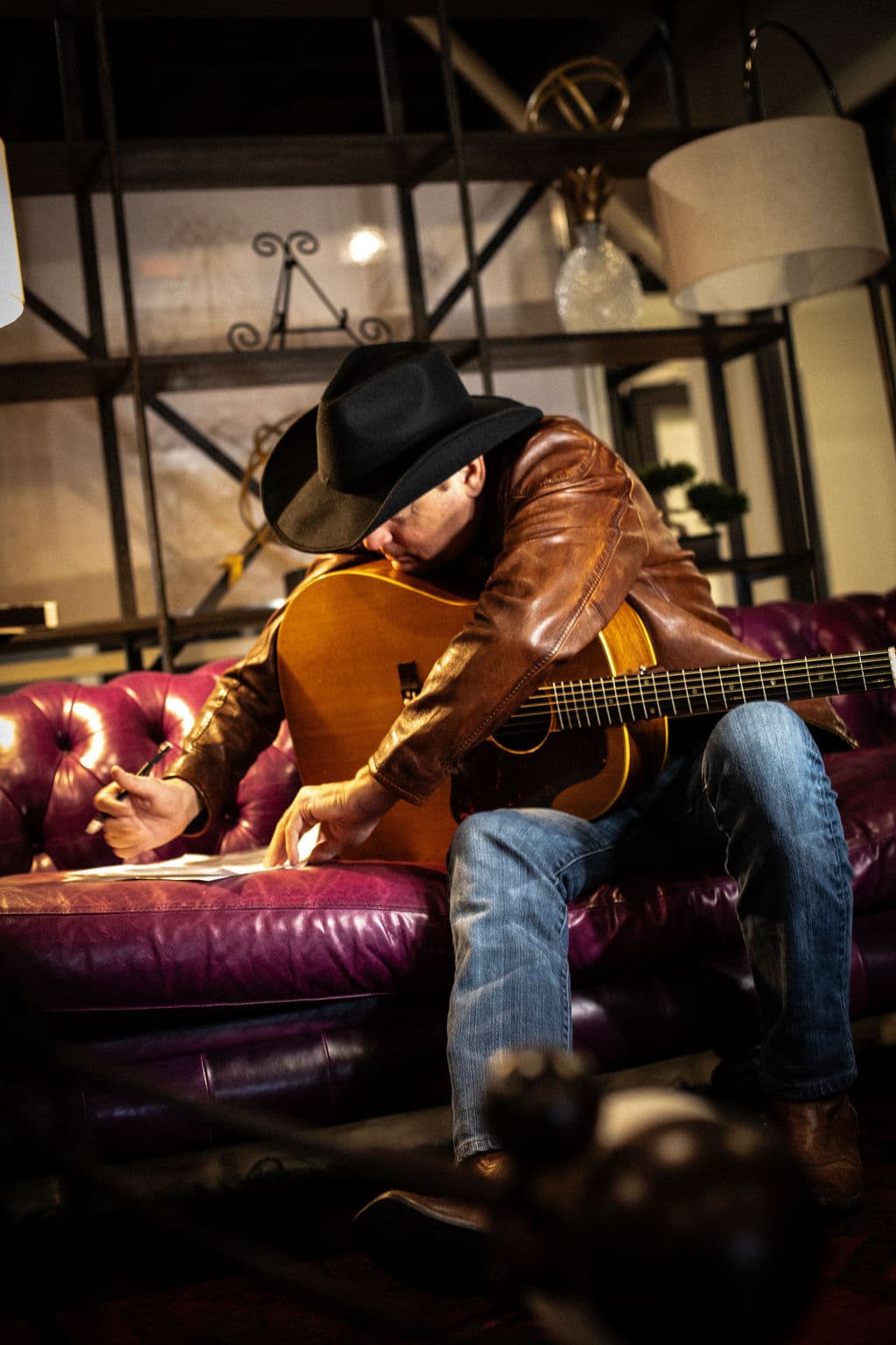Bo Adams songwriting on a chesterfield sofa